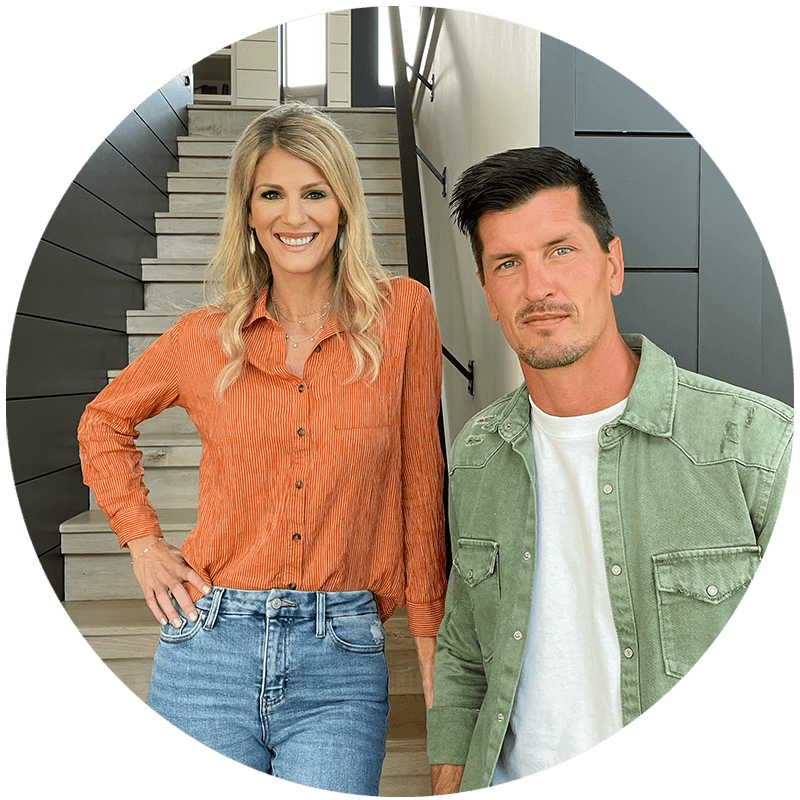 A Caucasian woman in an orange shirt and a Caucasian man in a green shirt are standing in front of an apartment's staircase.