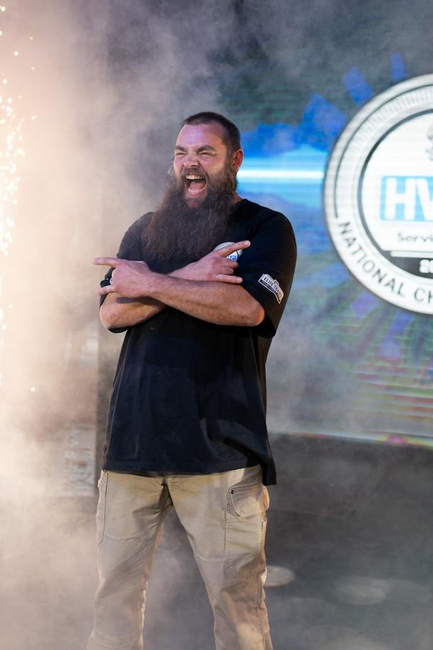 A man is standing front stage with fireworks behind him.