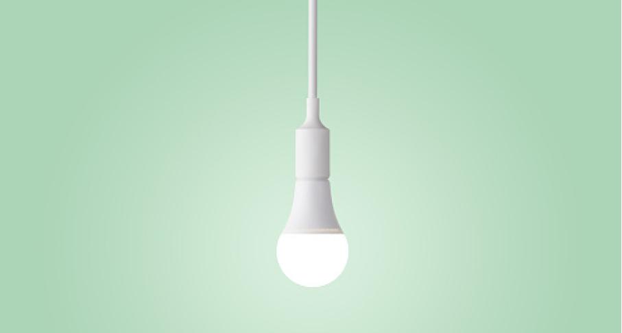 An energy efficient light bulb against a green background.