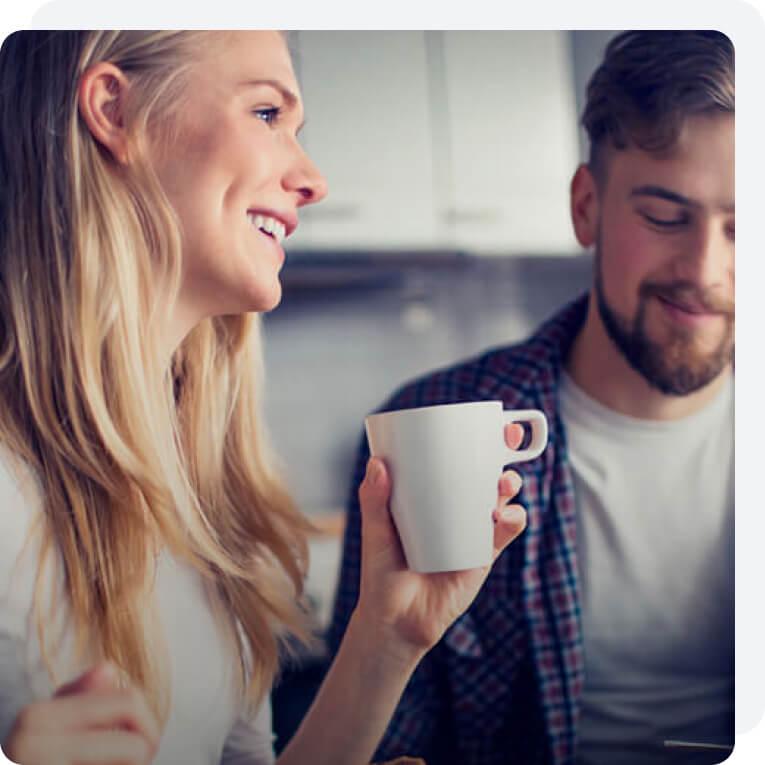 A woman is enjoying a warm beverage in a mug.